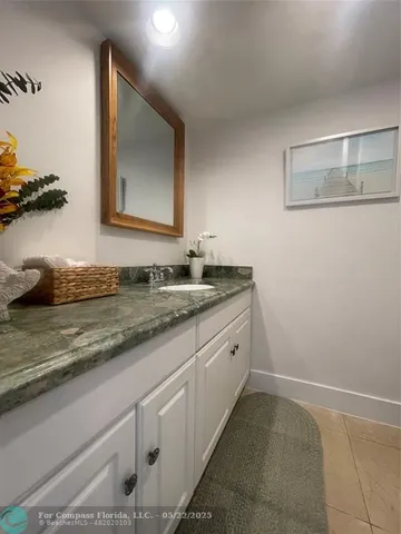 a bathroom with a granite countertop sink and a mirror