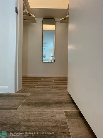 a view of a hallway and a room with wooden floor