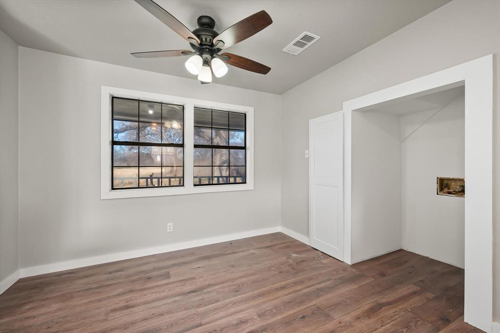 443 County Road 3799 Springtown, TX 76082 - Photo 19 of 33 Empty room with dark wood-style floors and a ceiling fan