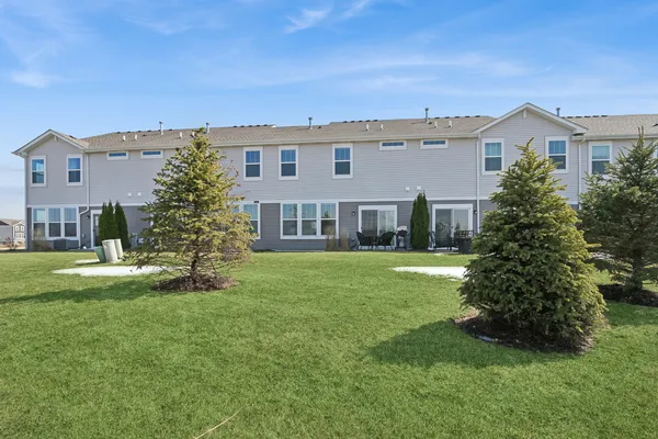 a view of a house with a big yard plants and large trees
