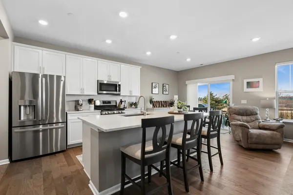 a kitchen with refrigerator a microwave and furniture