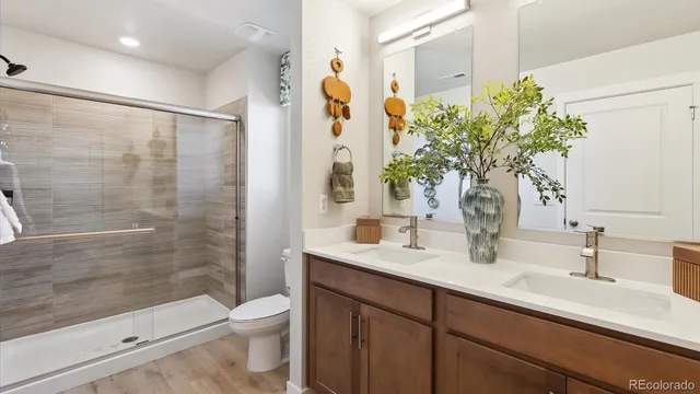 a bathroom with a granite countertop sink a toilet and shower