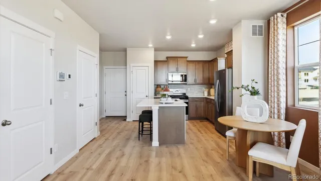 a kitchen with sink a refrigerator and chairs