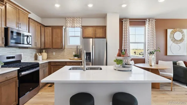 a kitchen with kitchen island granite countertop a sink a counter space appliances and cabinets