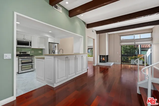 a view of a kitchen with wooden floor and electronic appliances