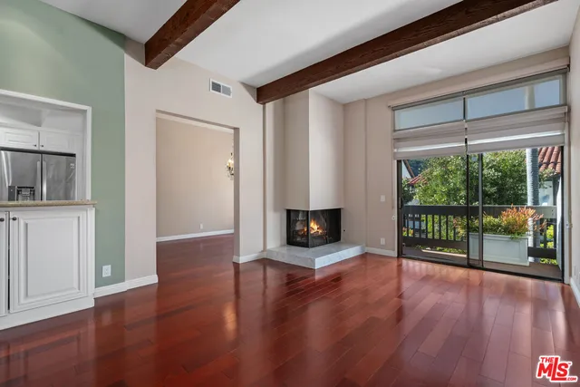 a view of a livingroom with wooden floor and a fireplace