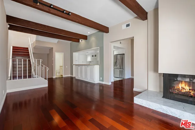 a view of a livingroom with wooden floor and a fireplace