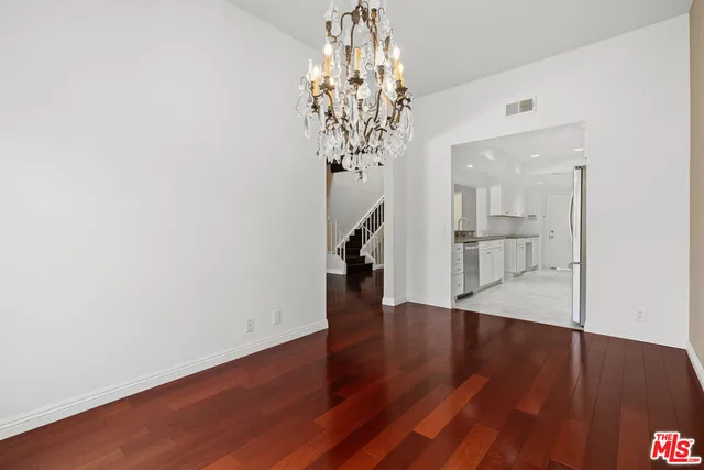 a view of a hallway with wooden floor and a chandelier