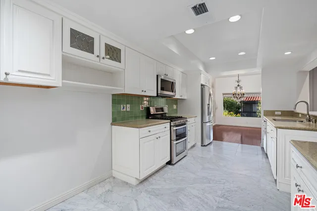 a kitchen with stainless steel appliances granite countertop a sink and stove top oven