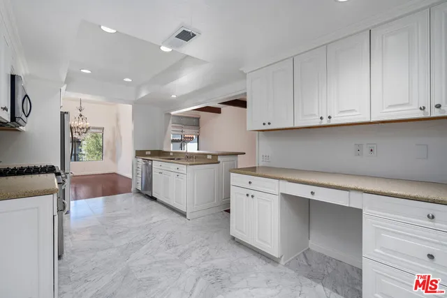a kitchen with white cabinets and white appliances