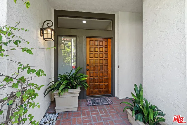 a vase with flowers sitting on a floor in front of a door