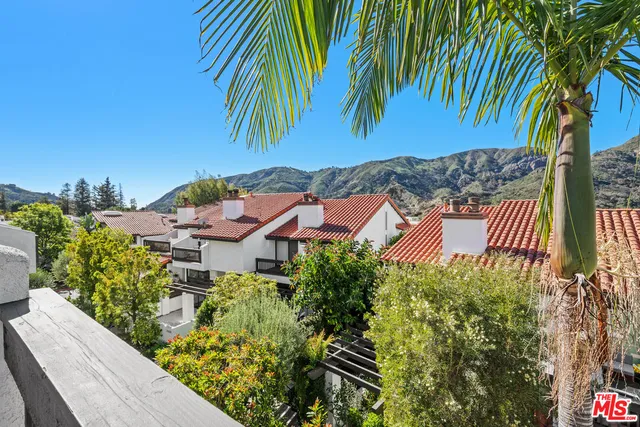 an aerial view of a house with garden space and trees
