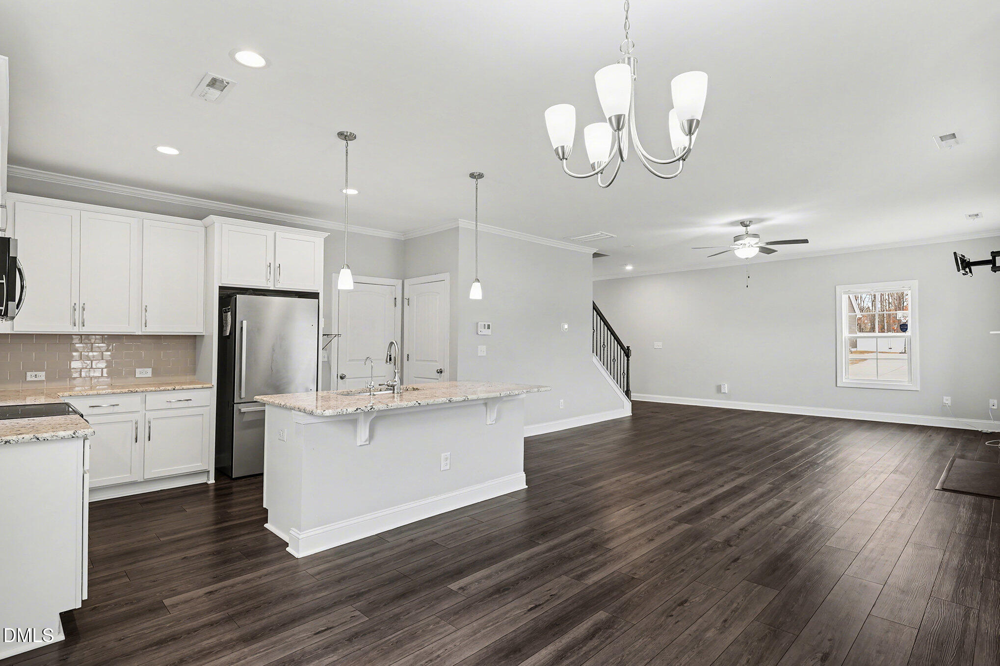 274 Howards Crossing Drive Wendell, NC 27591 - Photo 7 of 40 a kitchen with stainless steel appliances granite countertop wooden floors and granite counter tops