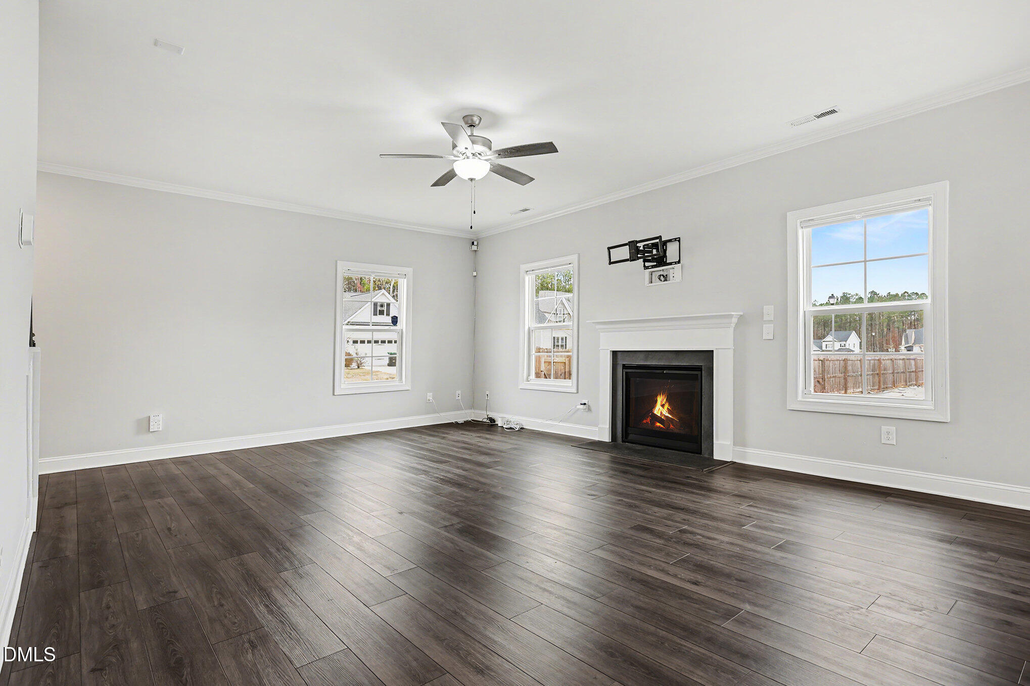 274 Howards Crossing Drive Wendell, NC 27591 - Photo 5 of 40 an empty room with windows a fireplace and wooden floor