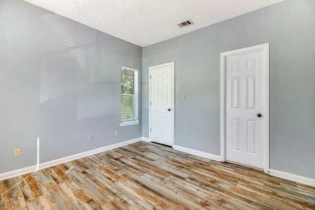 a view of a room with wooden floor