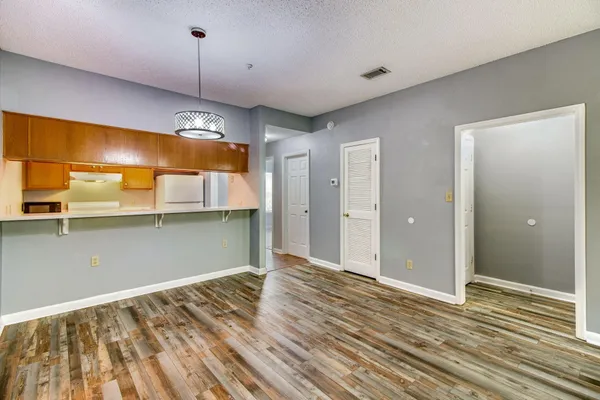 a view of a room with wooden floor and a ceiling fan