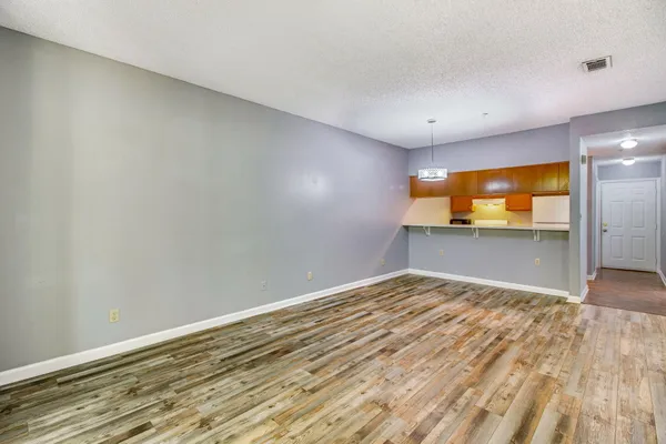 a view of empty room with wooden floor