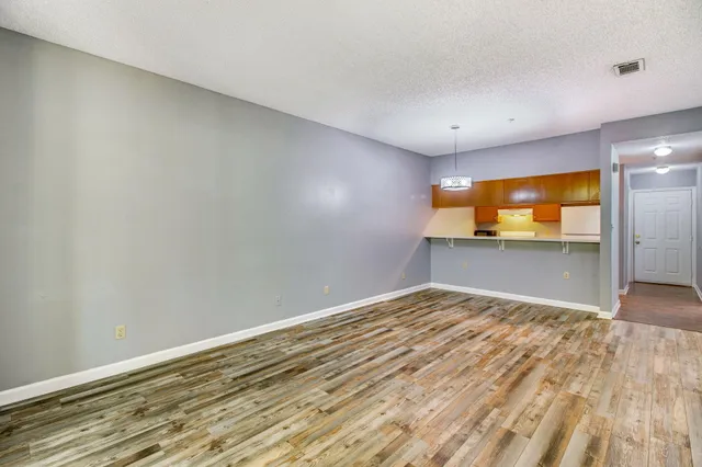 a view of empty room with wooden floor