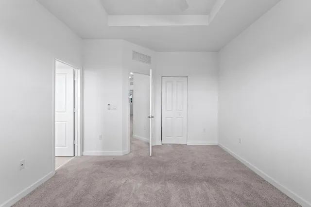 an empty room with closet and a chandelier fan