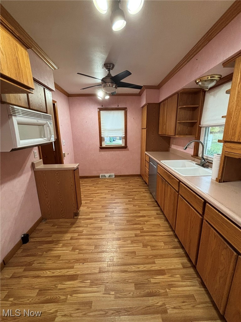 1039 Center Road Eastlake, OH 44095 - Photo 10 of 29 Kitchen with dishwasher, sink, light vinyl/wood-style floors, ceiling fan, and ornamental molding
