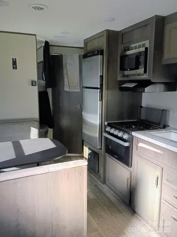 a kitchen with granite countertop a refrigerator stove and microwave