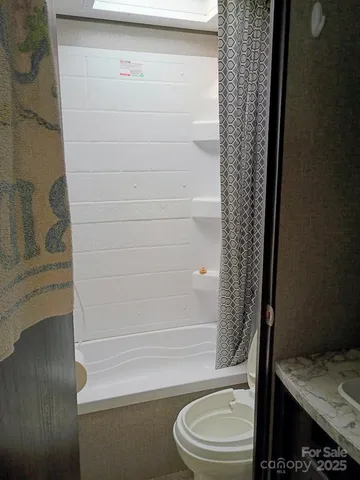 a bathroom with a toilet and a shower