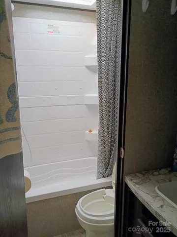 a bathroom with a toilet and a shower