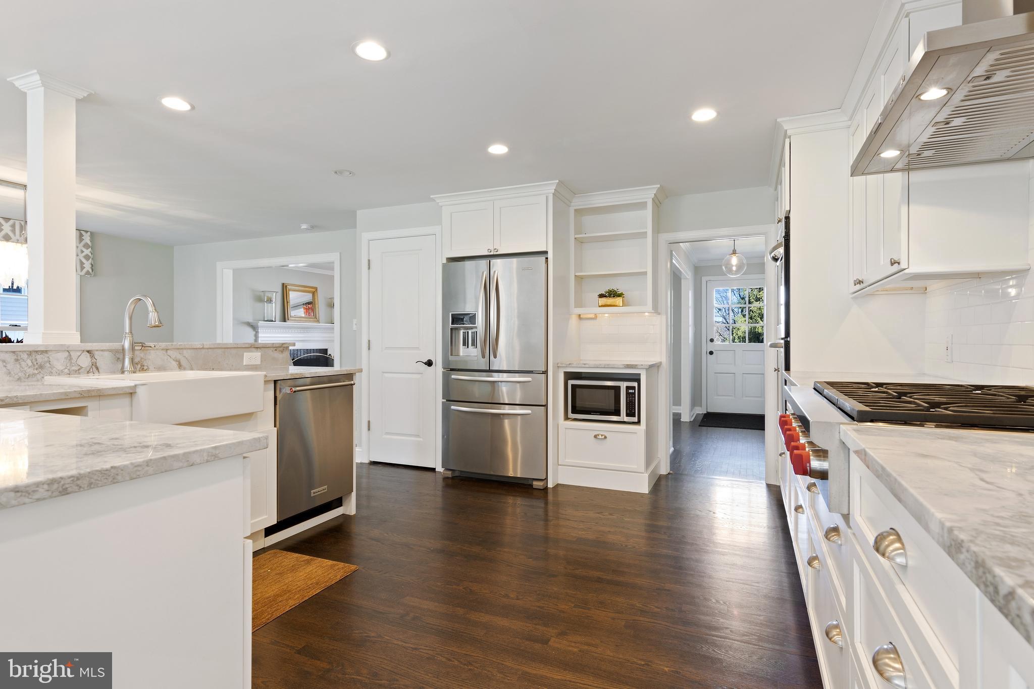 129 Clover Hill Lane Wayne, PA 19087 - Photo 6 of 41 a kitchen with granite countertop a refrigerator a sink dishwasher and white cabinets with wooden floor