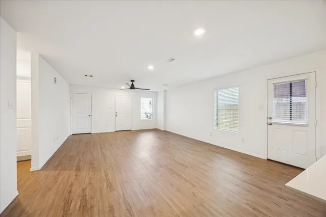 an empty room with wooden floor and windows