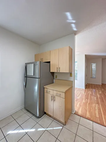 a kitchen with white cabinets and refrigerator