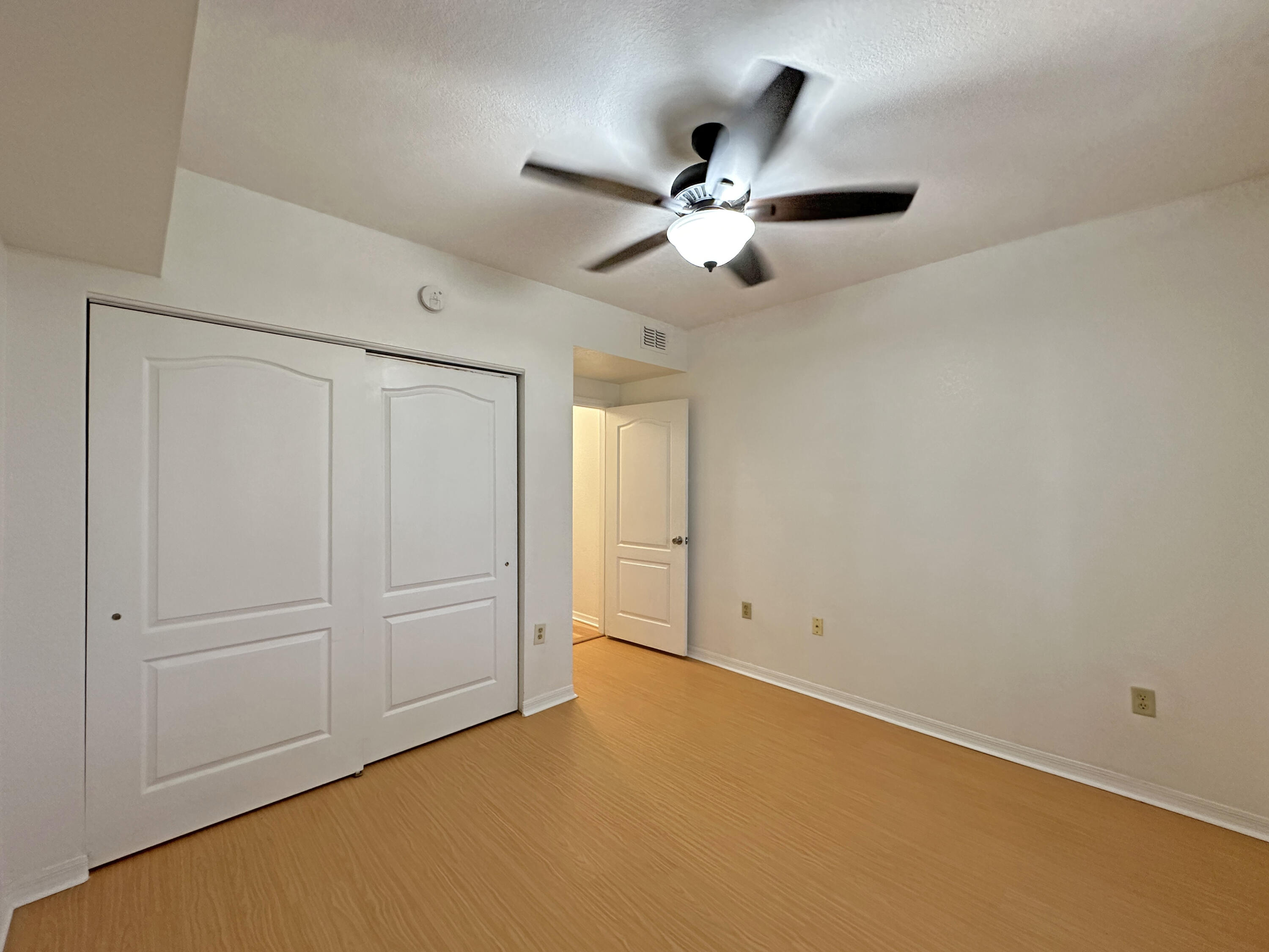 166 Southwest Peacock Boulevard, Unit 104 Port St. Lucie, FL 34986 - Photo 20 of 45 an empty room with closet and fan