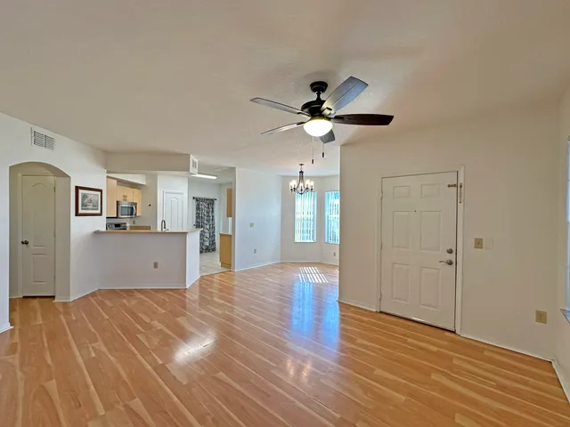 a view of a kitchen with wooden floor and a ceiling fan