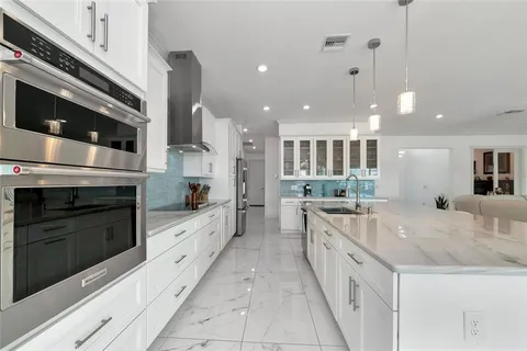 a kitchen with stainless steel appliances granite countertop a refrigerator and cabinets