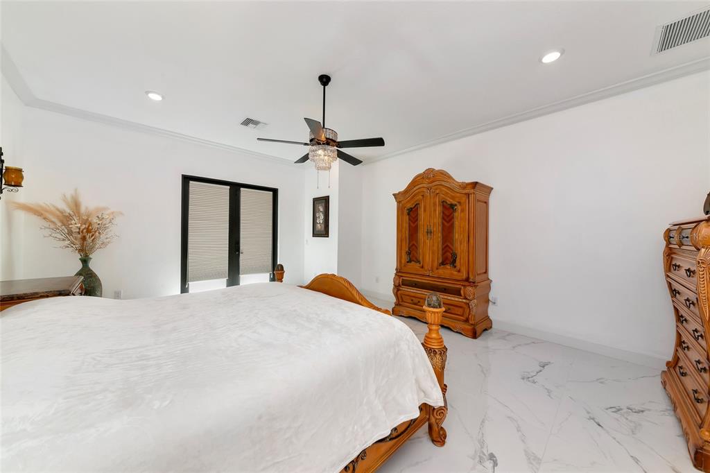 7505 27th Avenue West Bradenton, FL 34209 - Photo 27 of 66 a bedroom with a bed and dresser with mirror