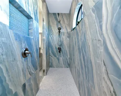 a room with lots of white furniture and a chandelier