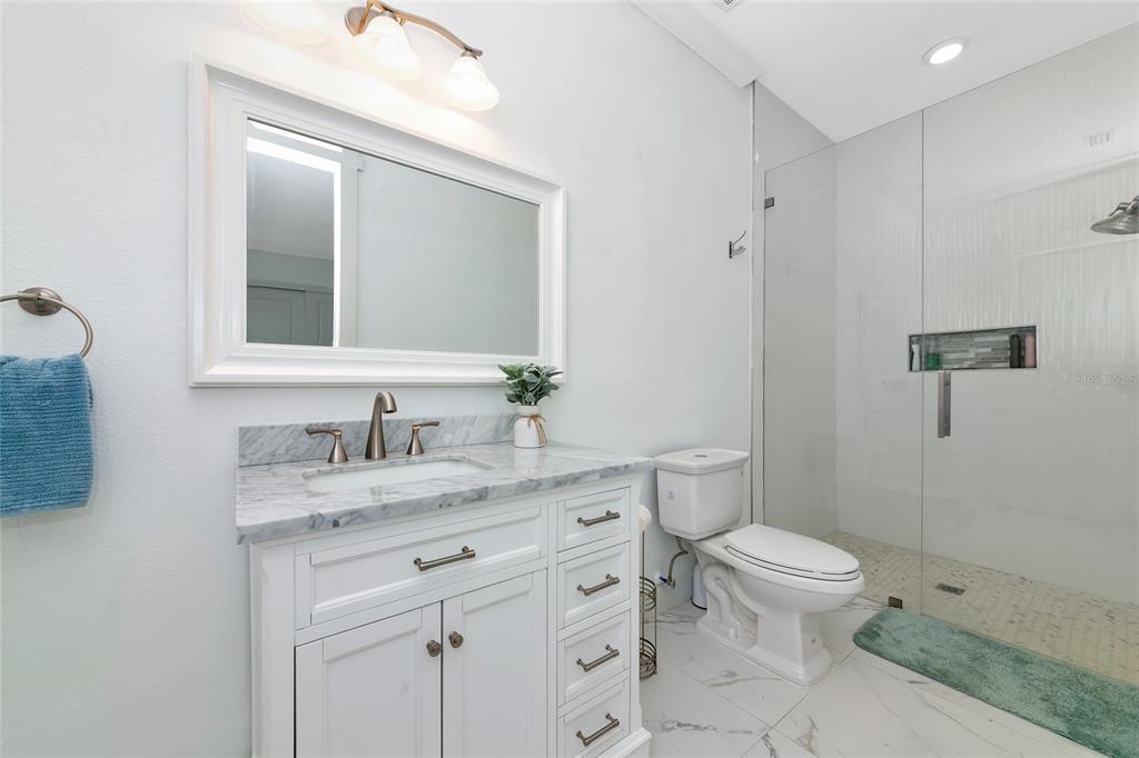 7505 27th Avenue West Bradenton, FL 34209 - Photo 38 of 66 a bathroom with a granite countertop toilet sink and a mirror