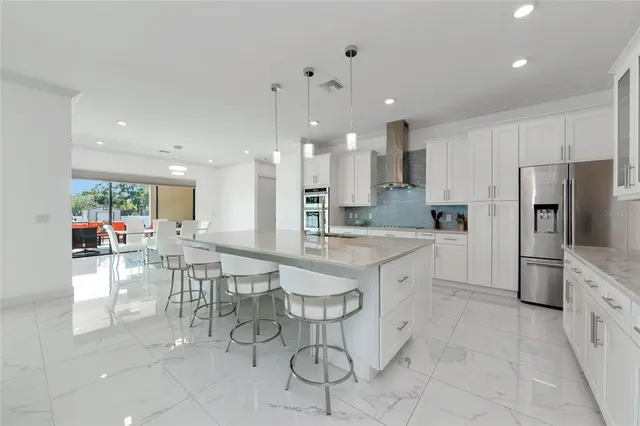 a large white kitchen with a stove top oven