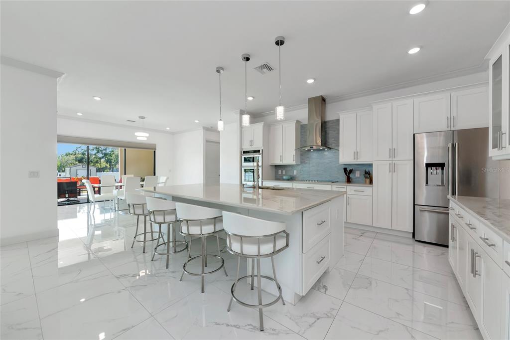 7505 27th Avenue West Bradenton, FL 34209 - Photo 8 of 66 a large kitchen with kitchen island granite countertop lots of counter space and stainless steel appliances