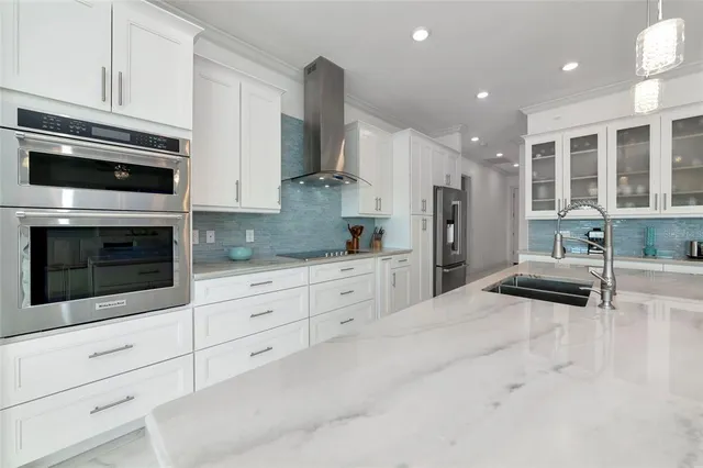 a kitchen with stainless steel appliances granite countertop a sink stove and cabinets