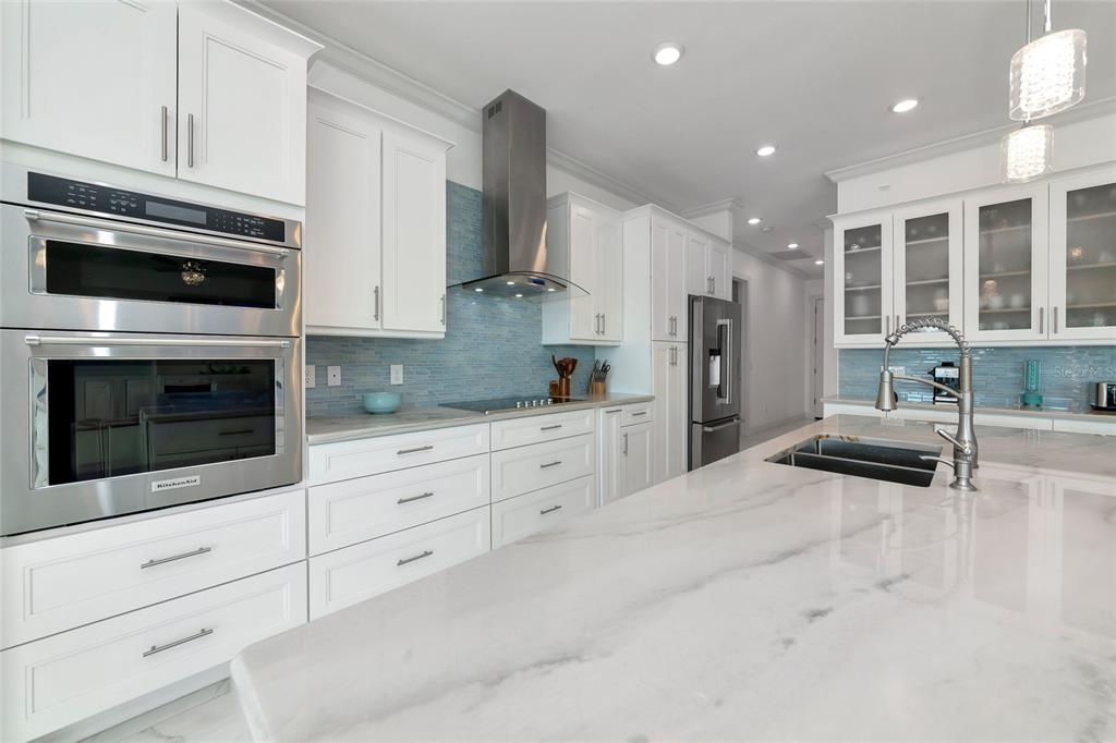 7505 27th Avenue West Bradenton, FL 34209 - Photo 10 of 66 a kitchen with stainless steel appliances kitchen island granite countertop a stove a sink and a microwave