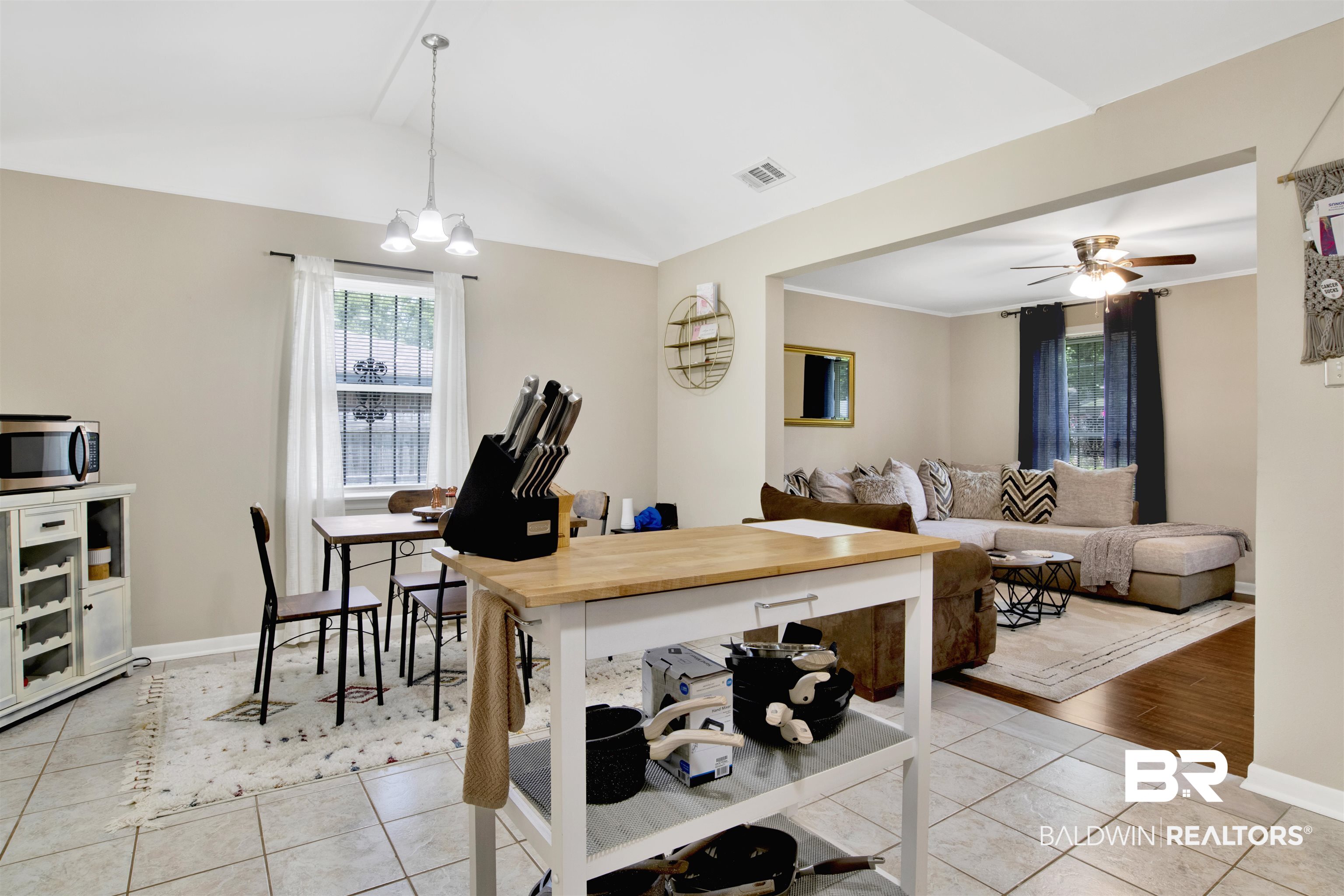 1476 Boudousquie Street Mobile, AL 36605 - Photo 13 of 34 Dining area featuring plenty of natural light, light tile patterned flooring, lofted ceiling, ceiling fan, and a chandelier