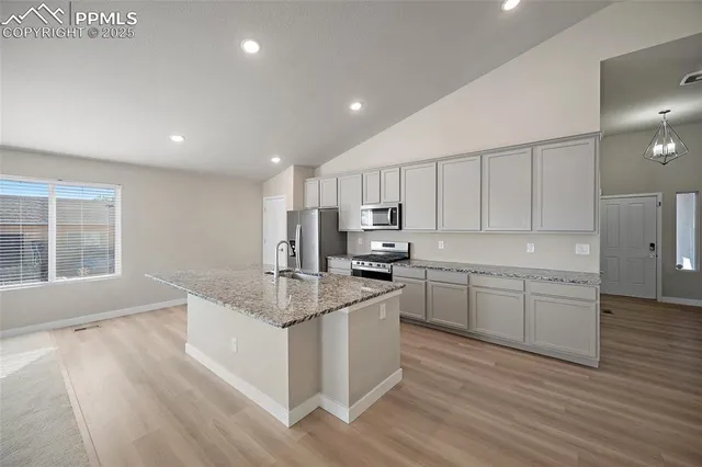 a kitchen with stainless steel appliances granite countertop refrigerator sink and cabinets