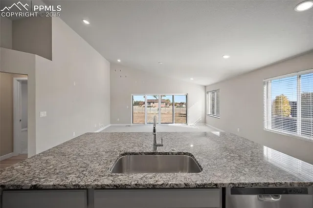 a kitchen with granite countertop a sink and a window
