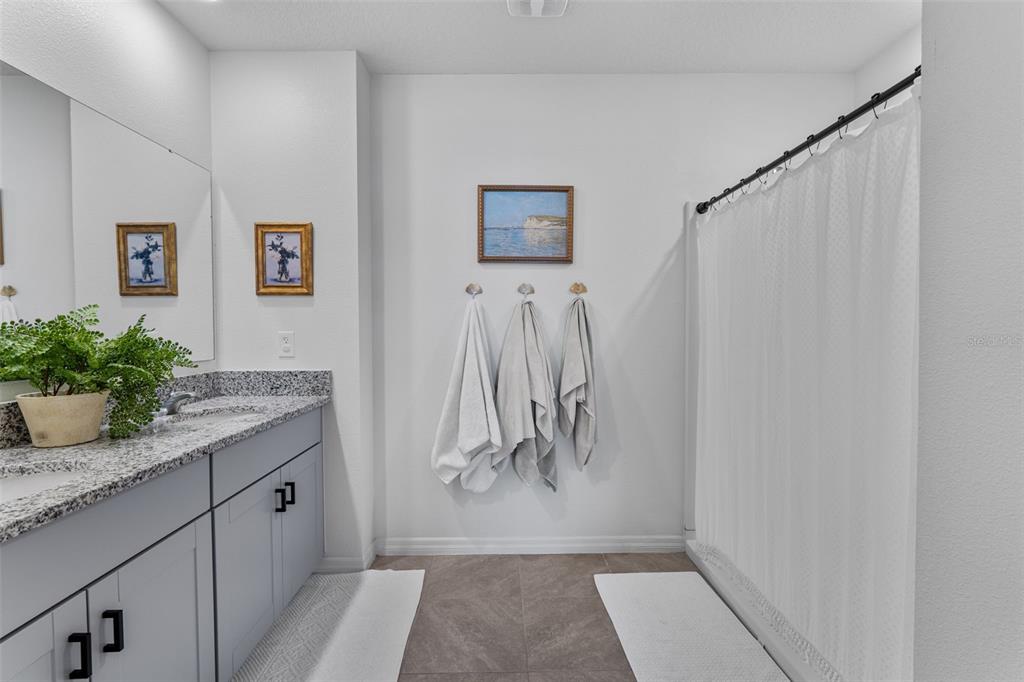 113 Camilla Road DeLand, FL 32724 - Photo 31 of 54 a bathroom with a granite countertop sink a mirror and shower