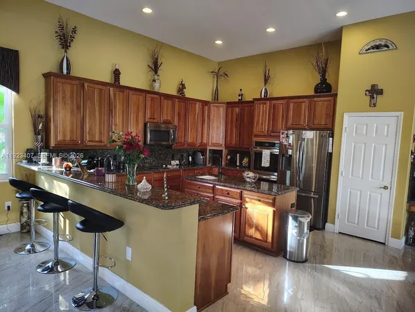 a kitchen with granite countertop a stove and a refrigerator
