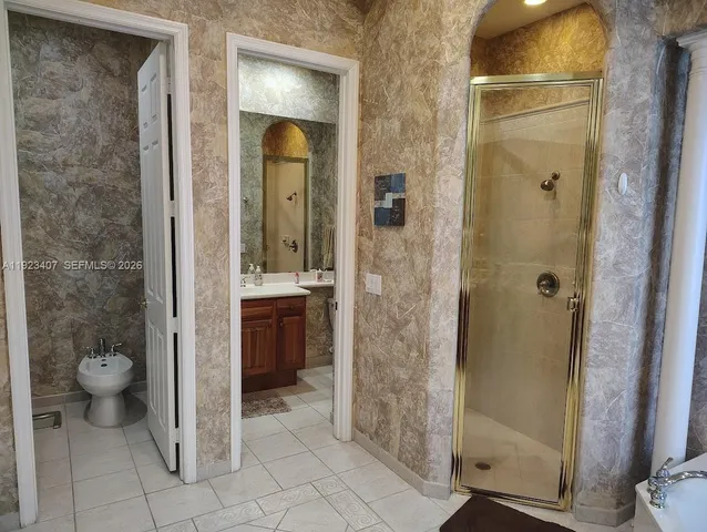 a bathroom with a granite countertop sink a toilet and shower
