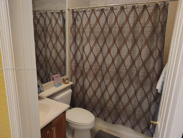 a white toilet sitting next to a white wall