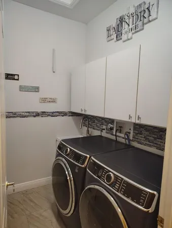 a utility room with sink dryer and washer