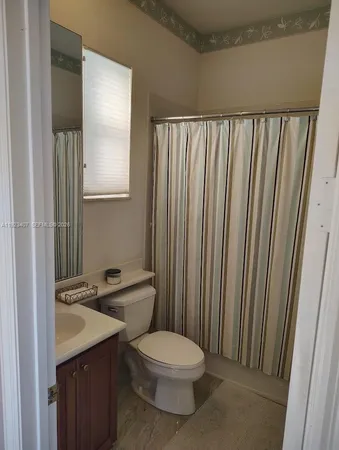 a bathroom with a toilet a sink and mirror