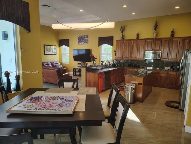 a kitchen with a table chairs stove and refrigerator